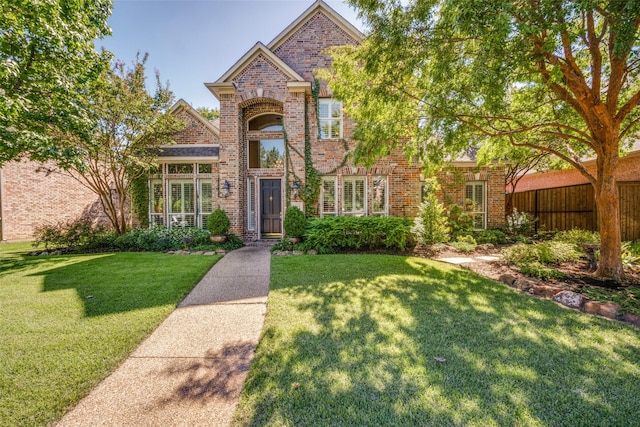 traditional-style home with brick siding and a front lawn