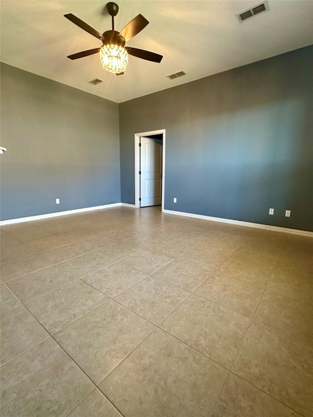 spare room featuring a ceiling fan, visible vents, and baseboards