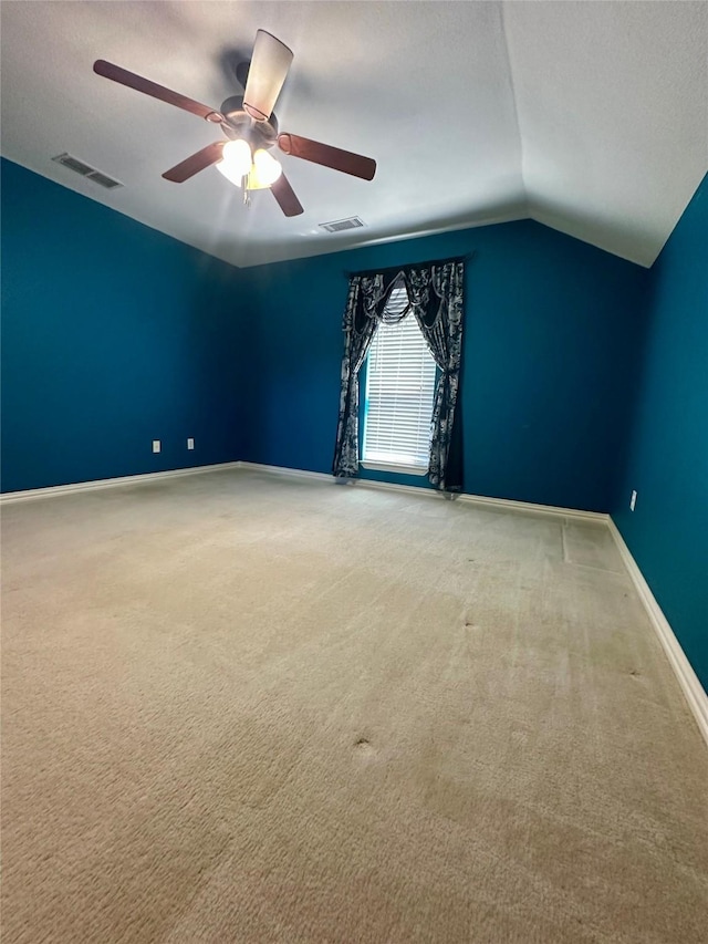 carpeted spare room featuring visible vents, vaulted ceiling, a textured ceiling, and baseboards