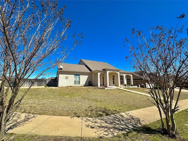 view of front of property featuring a front lawn, fence, and stucco siding