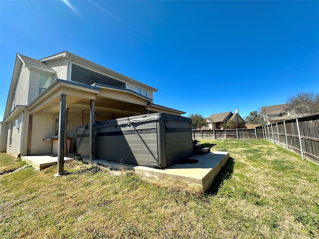 view of side of home with fence private yard, brick siding, and a lawn