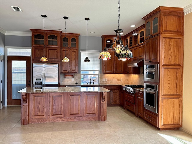 kitchen with a center island, crown molding, visible vents, appliances with stainless steel finishes, and under cabinet range hood