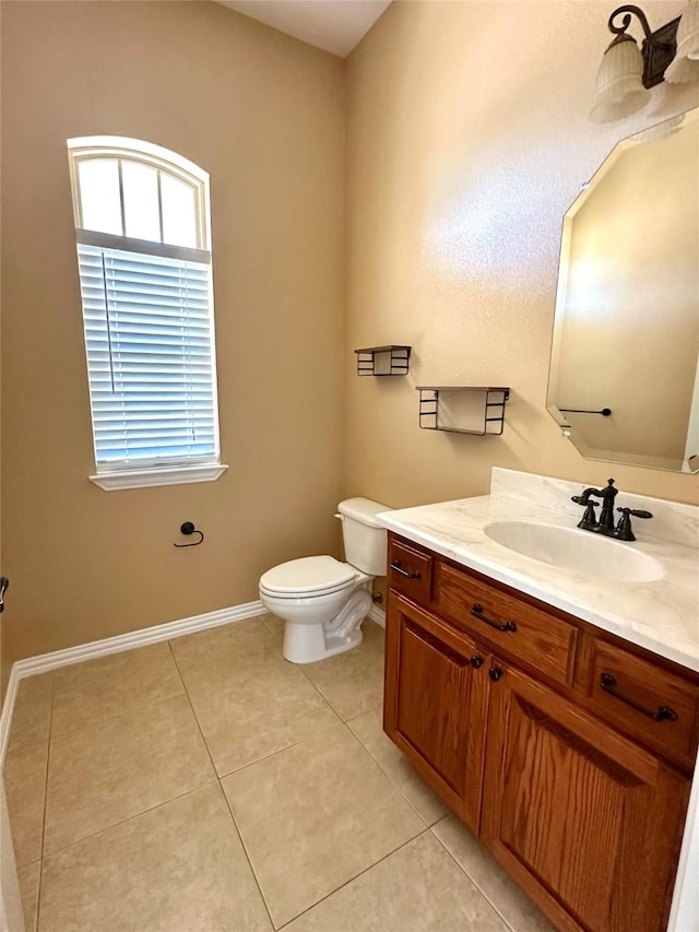 bathroom with baseboards, vanity, toilet, and tile patterned floors