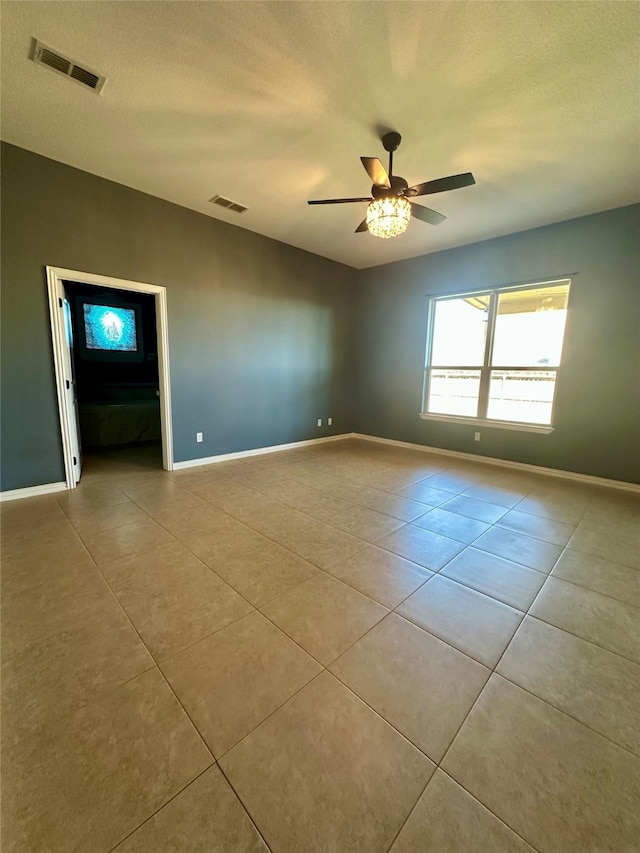 spare room featuring ceiling fan, a textured ceiling, visible vents, and tile patterned floors