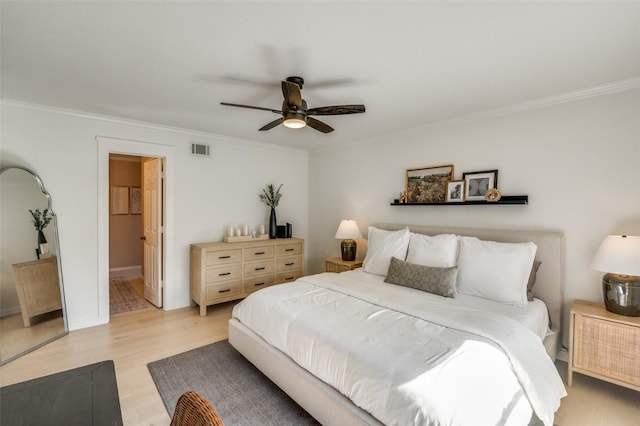 bedroom featuring a ceiling fan, light wood-type flooring, visible vents, and crown molding