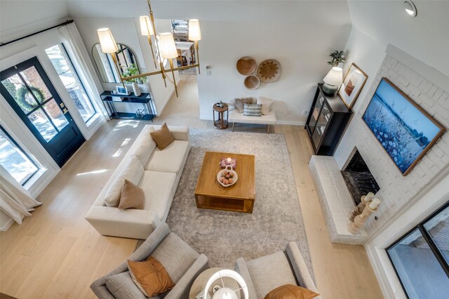 living area with a brick fireplace, wood finished floors, and baseboards