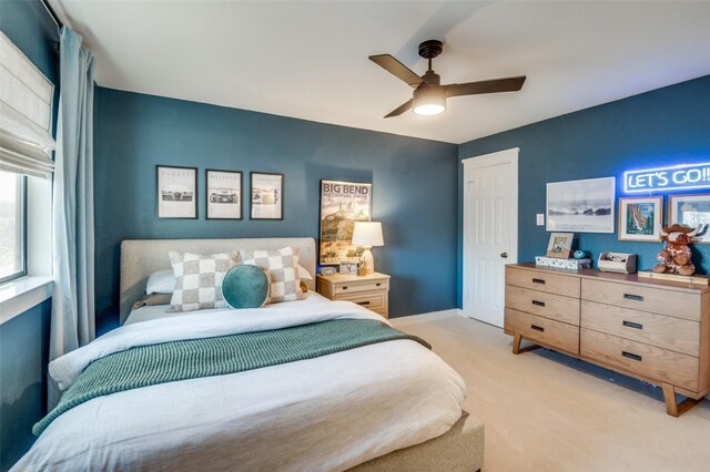 bedroom featuring baseboards, ceiling fan, a closet, and light colored carpet