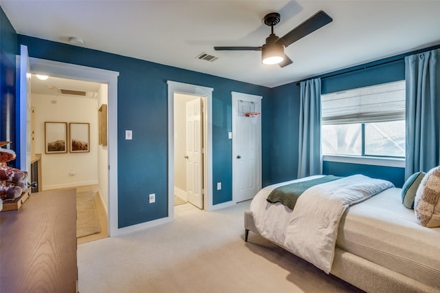 bedroom featuring carpet floors, visible vents, ensuite bathroom, ceiling fan, and baseboards