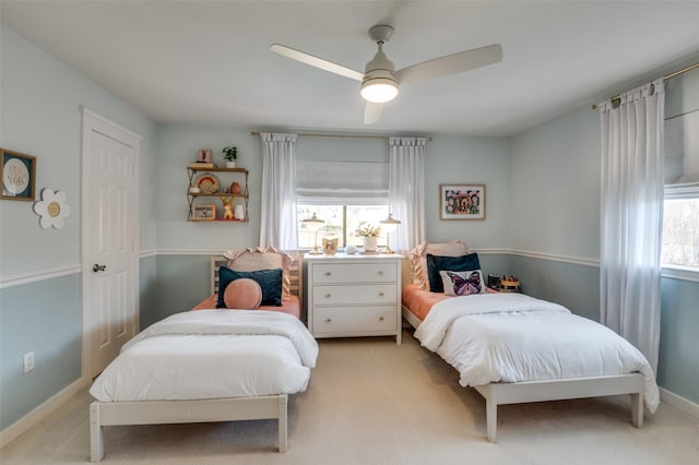 bedroom featuring light carpet, baseboards, and a ceiling fan