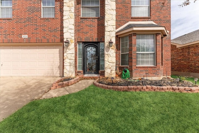 doorway to property featuring driveway, brick siding, and a lawn