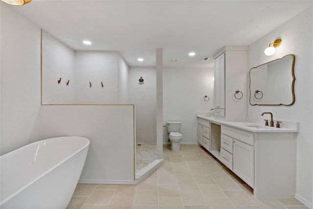 full bathroom with double vanity, a freestanding bath, toilet, a sink, and a walk in shower