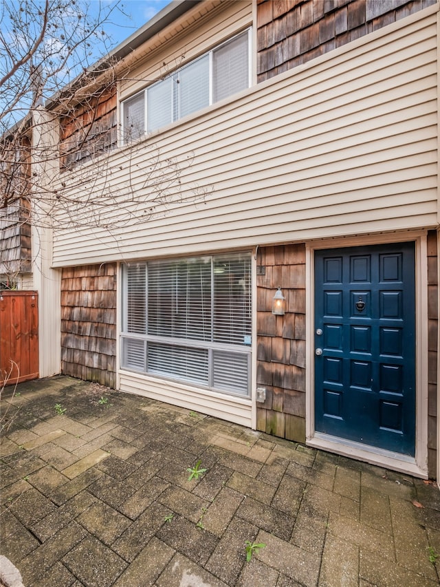 doorway to property featuring a garage, a patio area, and fence