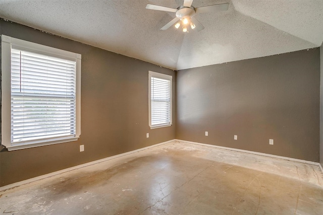 unfurnished room featuring ceiling fan, concrete floors, a textured ceiling, and lofted ceiling