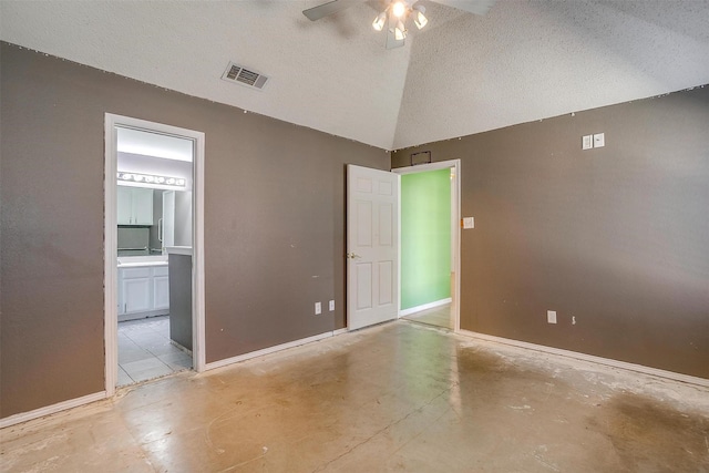 unfurnished room with visible vents, a ceiling fan, vaulted ceiling, a textured ceiling, and concrete floors