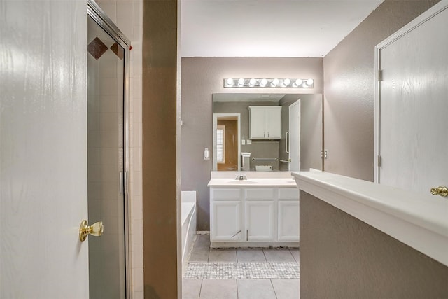 bathroom with a garden tub, tiled shower, vanity, and tile patterned floors