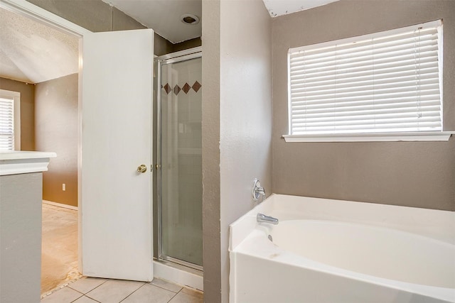 bathroom featuring a garden tub, a shower stall, a wealth of natural light, and tile patterned floors