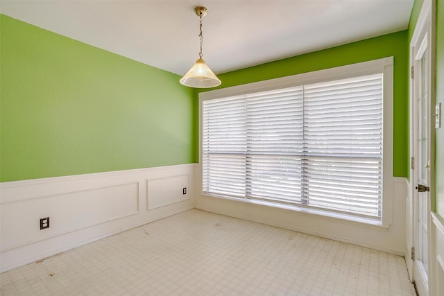 unfurnished room featuring a wainscoted wall and tile patterned floors