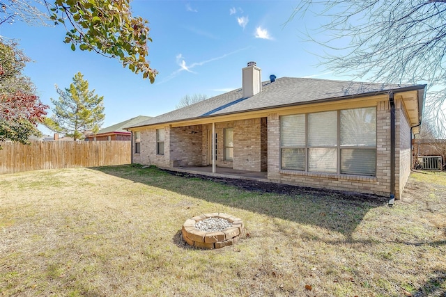 back of property with a patio, a chimney, fence, a yard, and brick siding