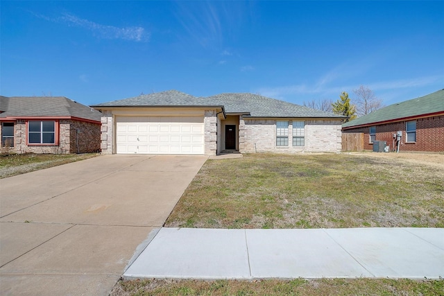 view of front of house featuring brick siding, an attached garage, cooling unit, driveway, and a front lawn