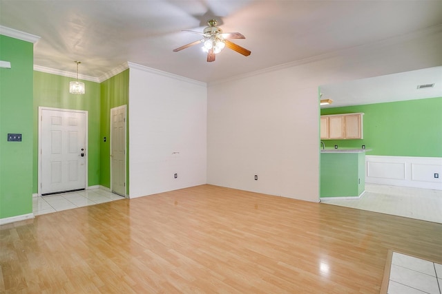 unfurnished living room featuring light wood-style floors, visible vents, ornamental molding, and a ceiling fan