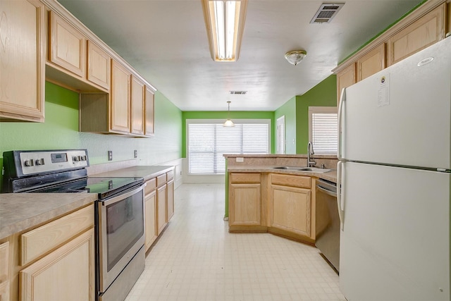 kitchen featuring light brown cabinets, stainless steel appliances, a sink, visible vents, and light floors