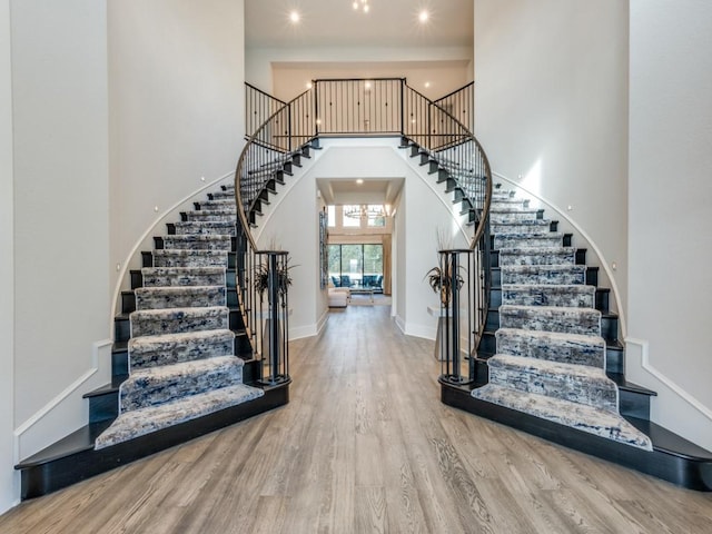 foyer entrance featuring recessed lighting, a high ceiling, wood finished floors, baseboards, and stairs