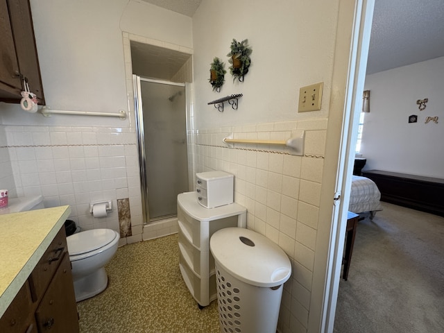 ensuite bathroom with a stall shower, ensuite bath, tile walls, and wainscoting