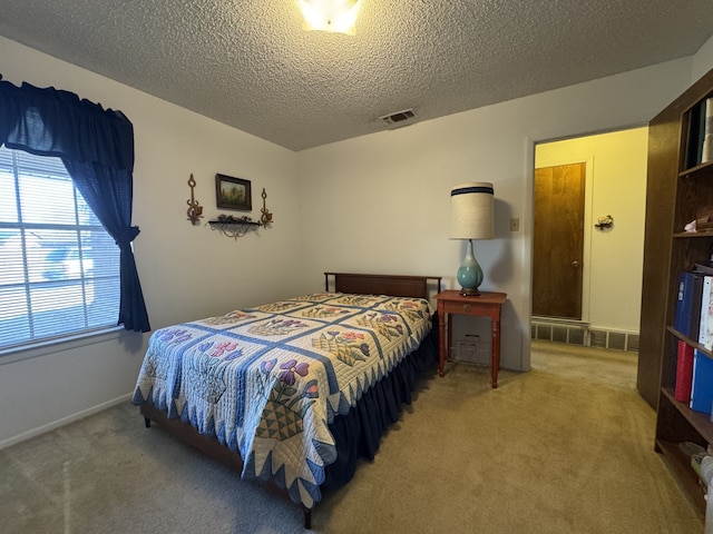 carpeted bedroom with visible vents, a textured ceiling, and baseboards