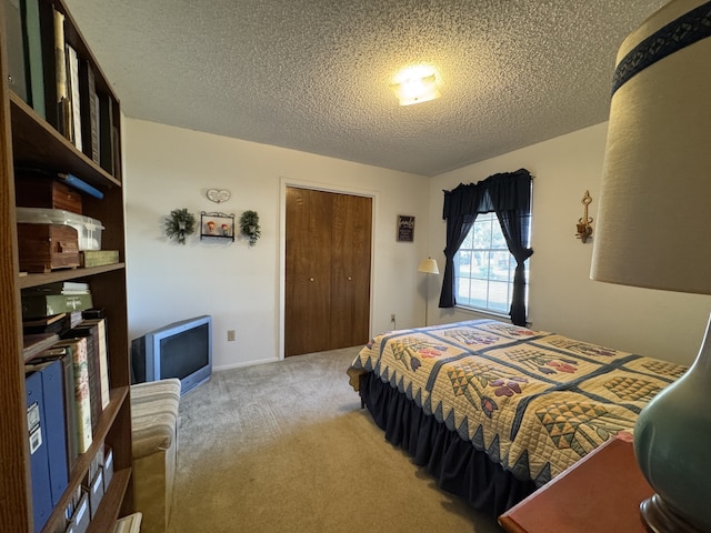 carpeted bedroom featuring a closet and a textured ceiling