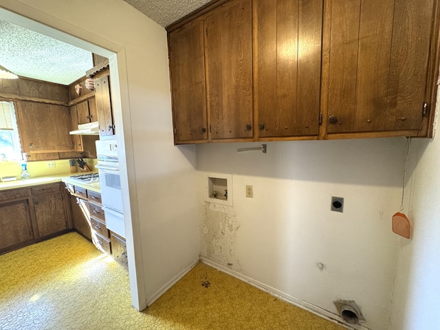 clothes washing area featuring light floors, washer hookup, cabinet space, and hookup for an electric dryer