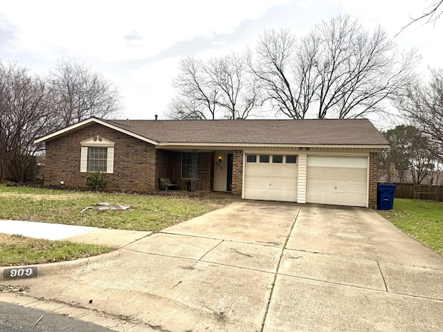 single story home with a garage, concrete driveway, brick siding, and a front yard