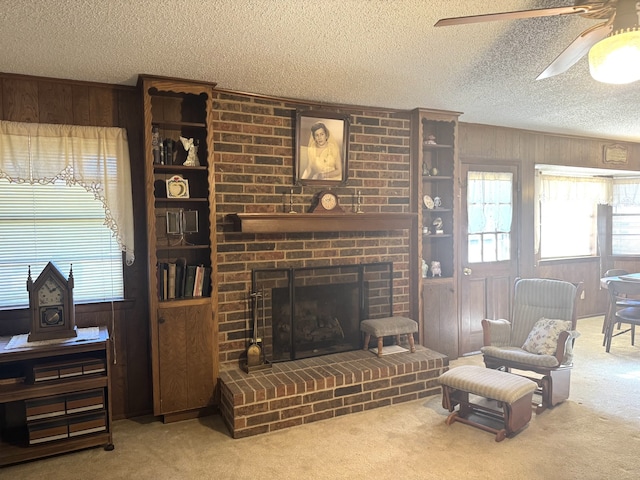 living room featuring wood walls, a fireplace, and carpet flooring