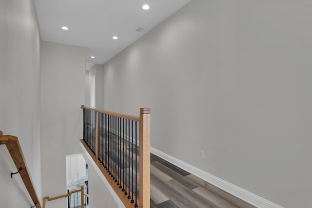 hall featuring recessed lighting, visible vents, an upstairs landing, wood finished floors, and baseboards