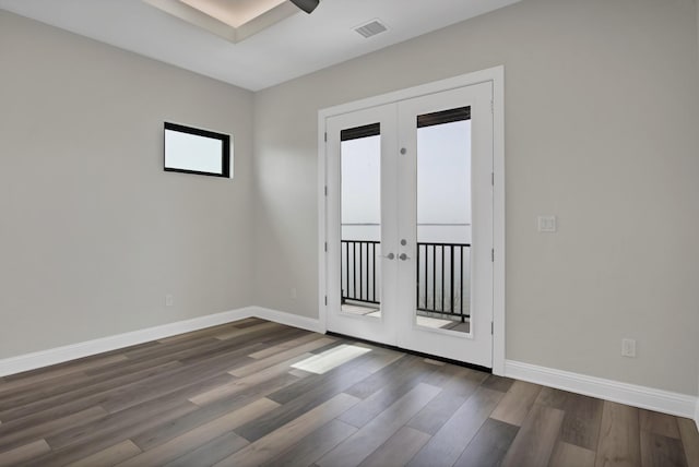 unfurnished room with french doors, visible vents, baseboards, and wood finished floors