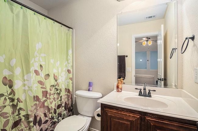 bathroom featuring toilet, vanity, visible vents, and a textured wall