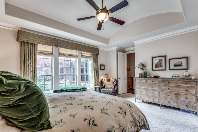 bedroom with lofted ceiling, light carpet, a ceiling fan, a raised ceiling, and crown molding