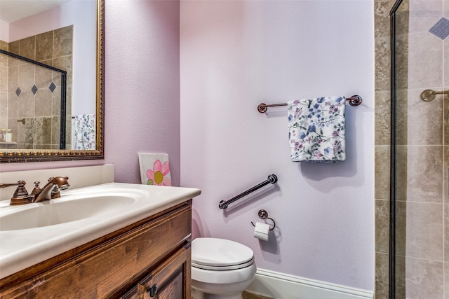 full bathroom featuring a stall shower, vanity, and toilet