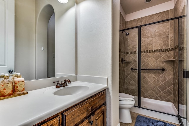 bathroom with a stall shower, tile patterned flooring, vanity, and toilet