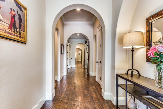 corridor featuring ornamental molding, dark wood-style flooring, and baseboards