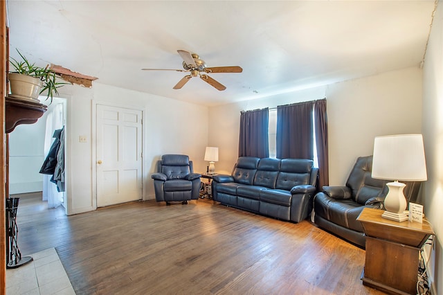 living room featuring ceiling fan, baseboards, and wood finished floors