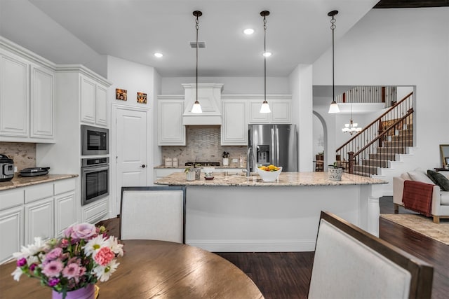 kitchen featuring stainless steel appliances, visible vents, custom range hood, dark wood-type flooring, and white cabinets