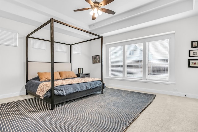 bedroom with baseboards, a tray ceiling, ceiling fan, and carpet flooring