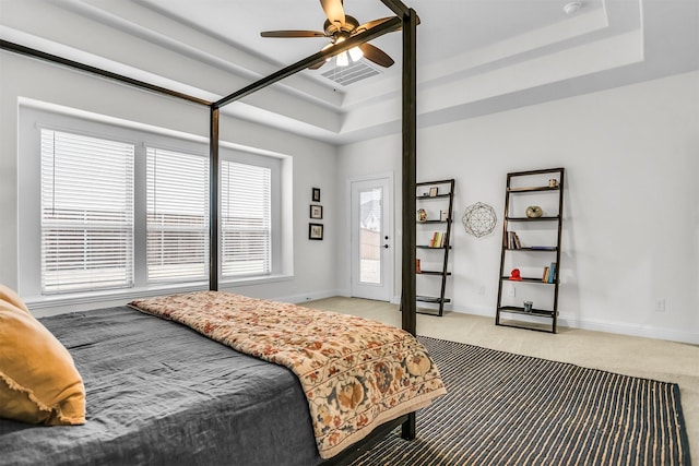 bedroom with light carpet, baseboards, and a tray ceiling