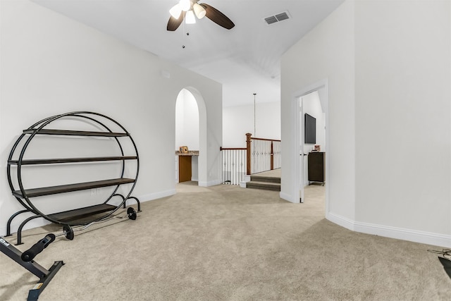 interior space with carpet, an upstairs landing, visible vents, and baseboards