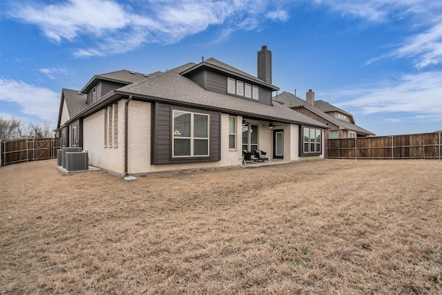 back of property featuring central AC unit, a fenced backyard, brick siding, a ceiling fan, and a patio area