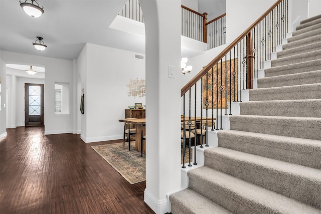 entrance foyer with stairs, wood finished floors, visible vents, and baseboards