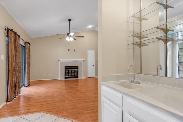 interior space featuring lofted ceiling, ceiling fan, wood finished floors, vanity, and a high end fireplace