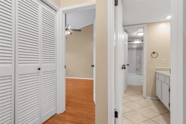 corridor featuring light tile patterned floors and baseboards