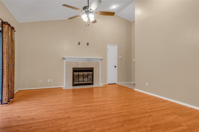 unfurnished living room featuring baseboards, vaulted ceiling, crown molding, light wood-type flooring, and a high end fireplace