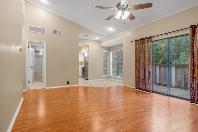 unfurnished room with light wood-style floors, lofted ceiling, visible vents, and ornamental molding